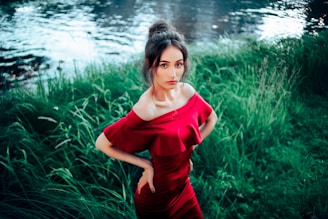 A close-up shot of a model wearing a flowing, modern dress from Cinque Fiumi, standing by a sunlit riverbank.