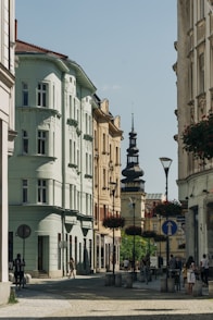 a group of people walking down a street next to tall buildings