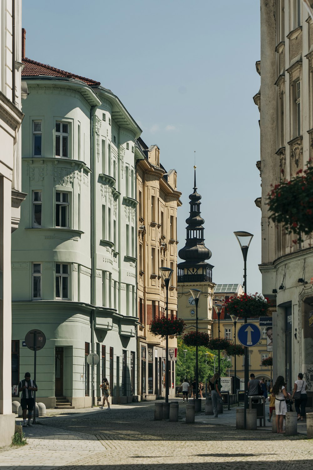 a group of people walking down a street next to tall buildings