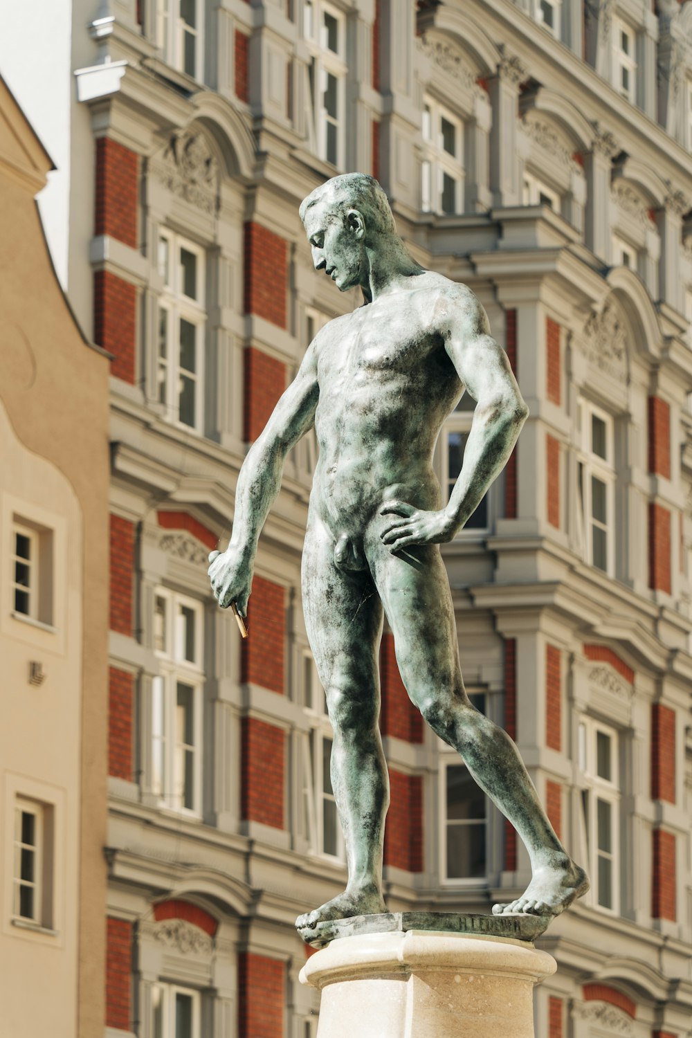 una statua di un uomo in piedi di fronte a un edificio