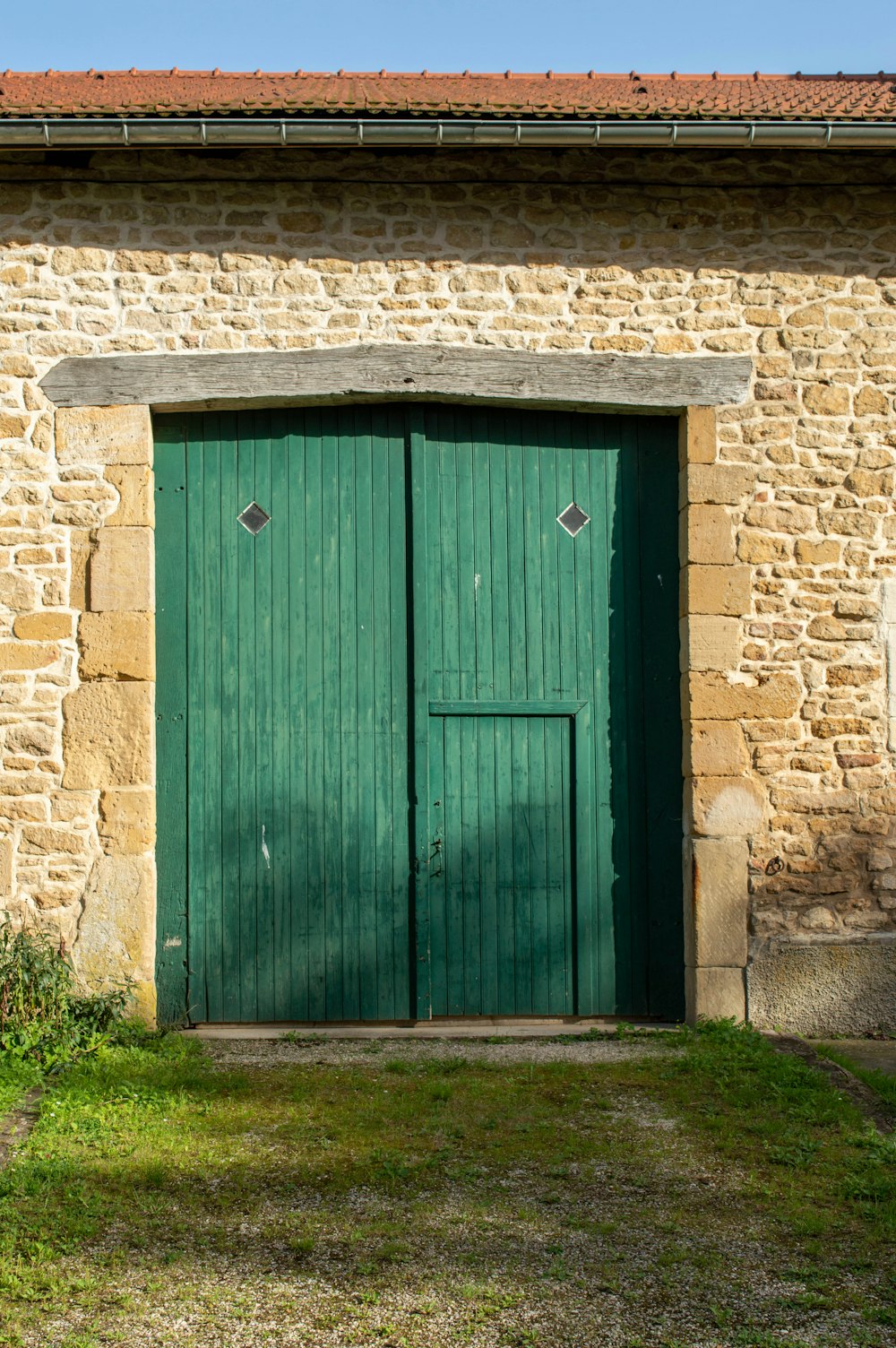 a green wooden door in a stone building