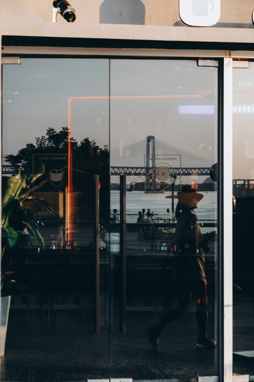 the reflection of a person walking in a glass door