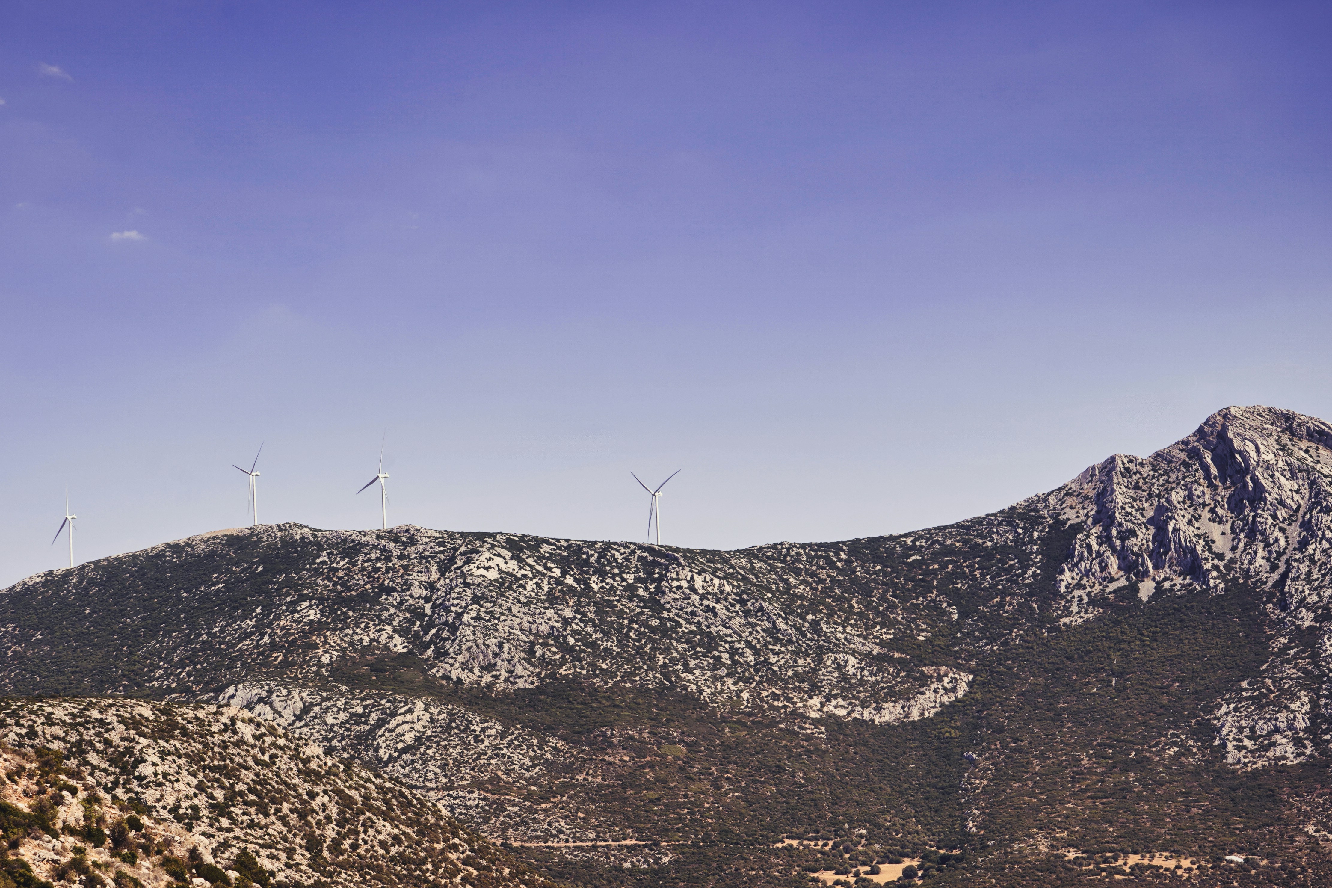 a view of a mountain with wind mills in the distance