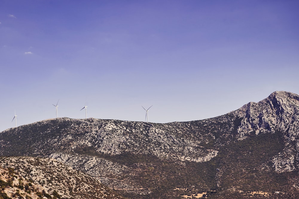 a view of a mountain with wind mills in the distance