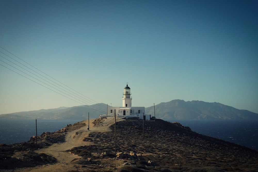 a white lighthouse on top of a hill