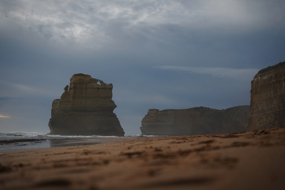 a large rock formation on a beach near the ocean