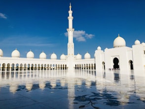 a large white building with a clock tower in the background