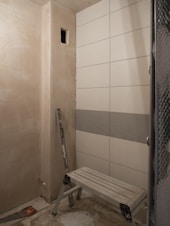 a bathroom with a bench and tiled walls