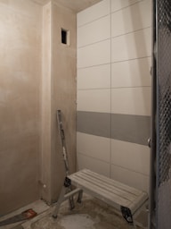 a bathroom with a bench and tiled walls