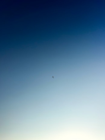 A sleek airplane silhouette against a clear blue sky symbolizing opportunity.