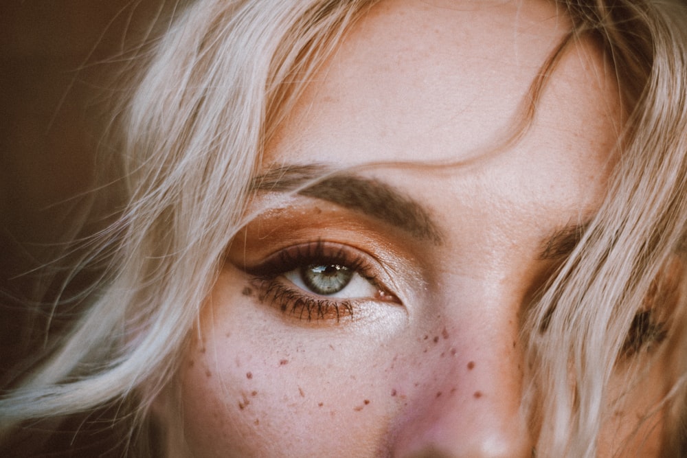 a close up of a woman's face with freckled hair