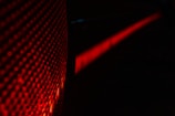 Close-up of sharp-edged legal papers under deep red lighting reflecting on metallic surfaces.