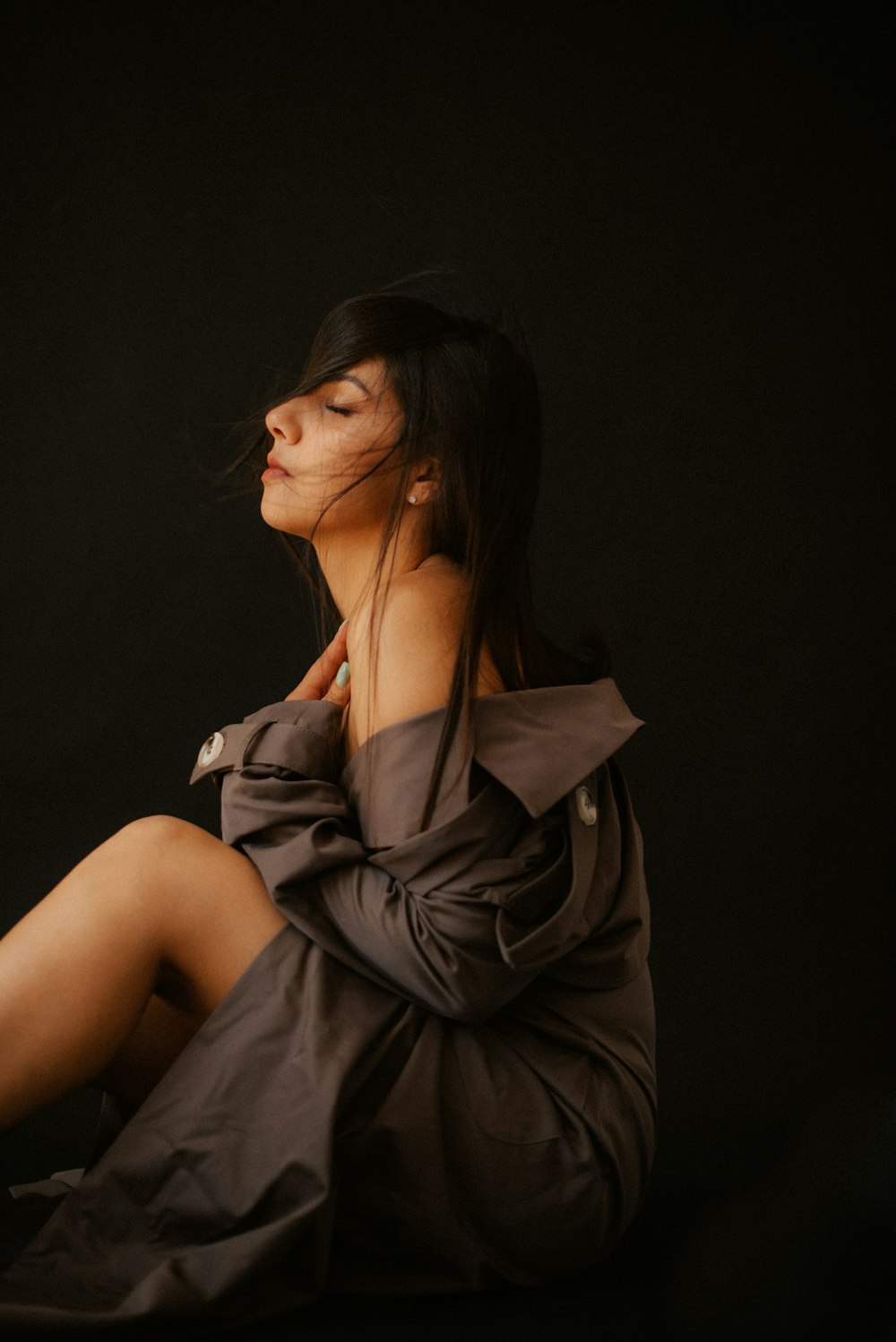 a woman sitting on the ground with her eyes closed