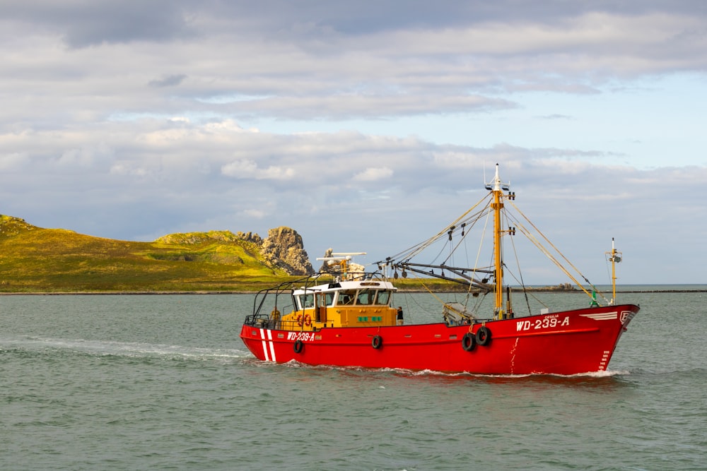 a large red boat in the middle of a body of water