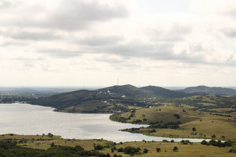 a view of a lake and mountains from a hill