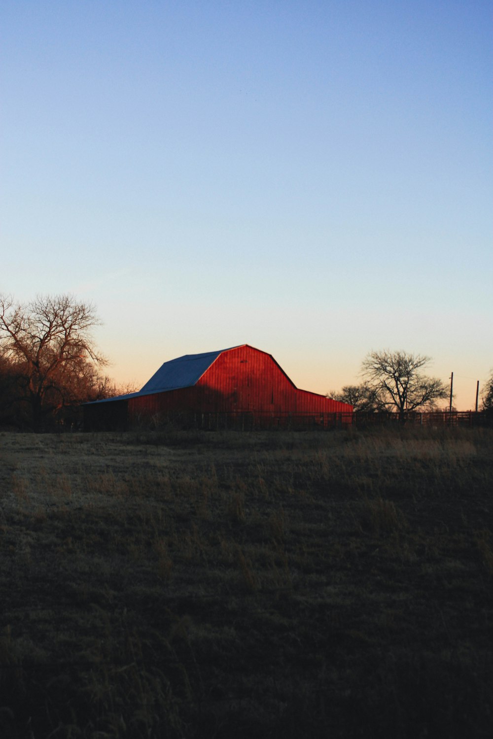a red barn in a field with trees in the background