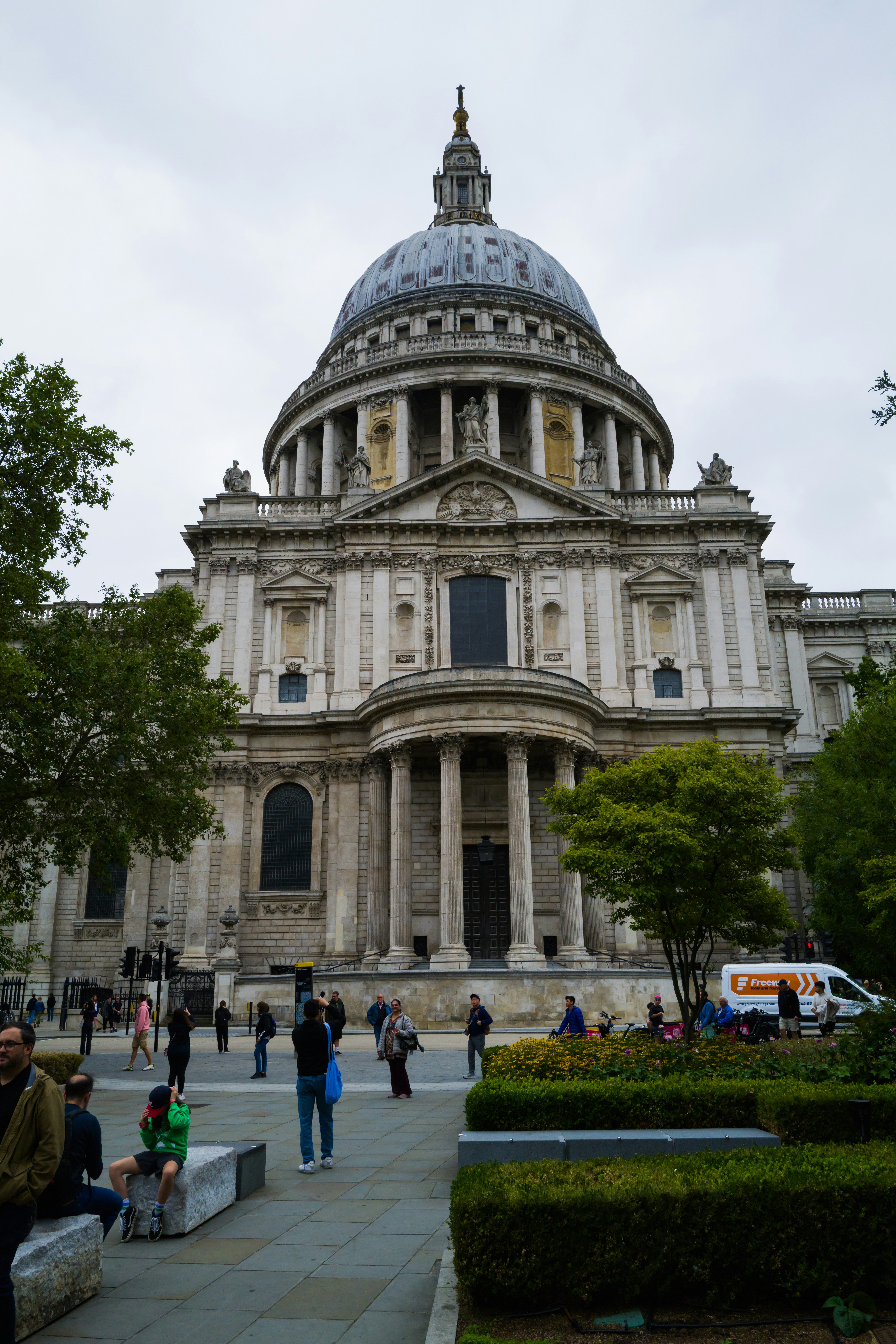 a group of people sitting on a bench in front of a building