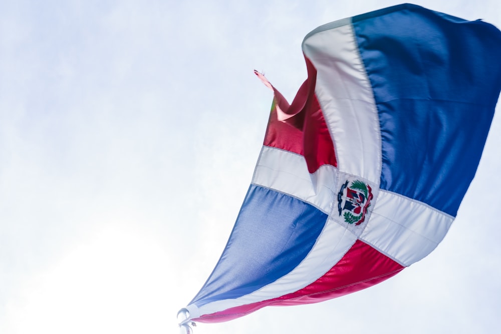 a flag flying in the air with a sky background