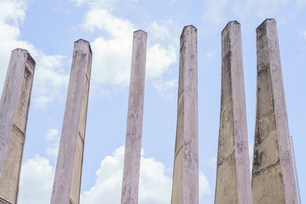 a row of cement pillars against a blue sky