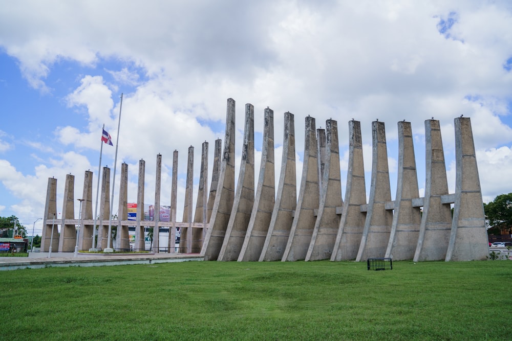 a row of concrete pillars in a grassy area