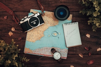 a map, a camera and a watch on a table