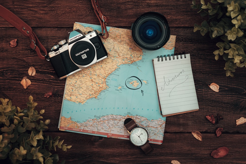 a map, a camera and a watch on a table