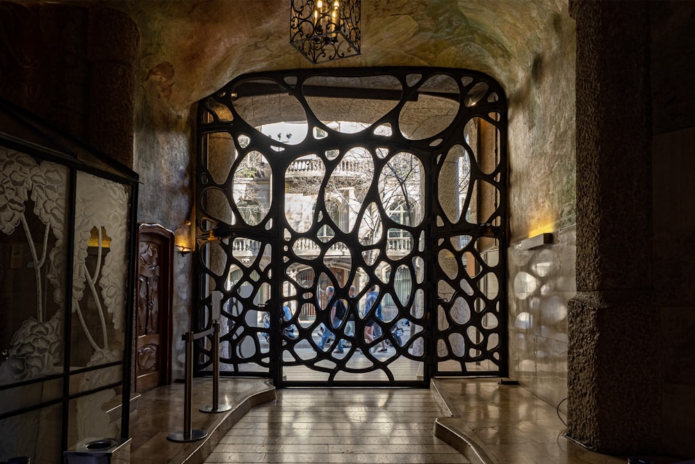 a large metal gate in a building with a chandelier hanging from the ceiling