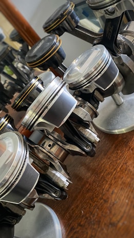 Close-up of a polished piston reflecting light in a sleek black and copper workshop setting.