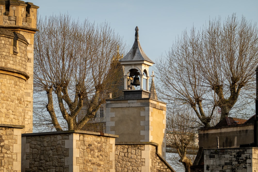 una torre dell'orologio con una campana in cima a un edificio