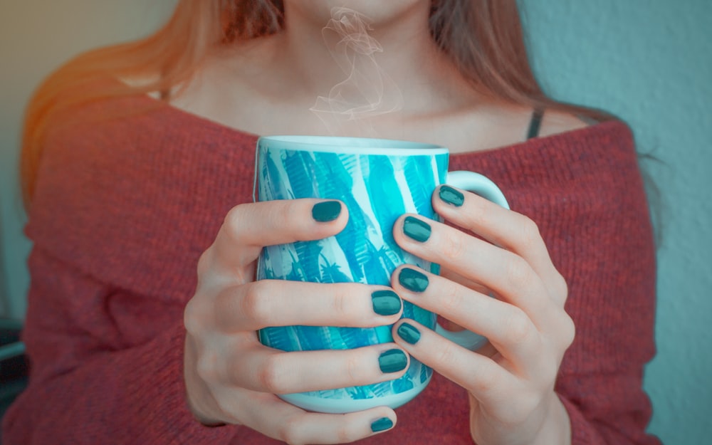 a woman holding a cup of coffee in her hands