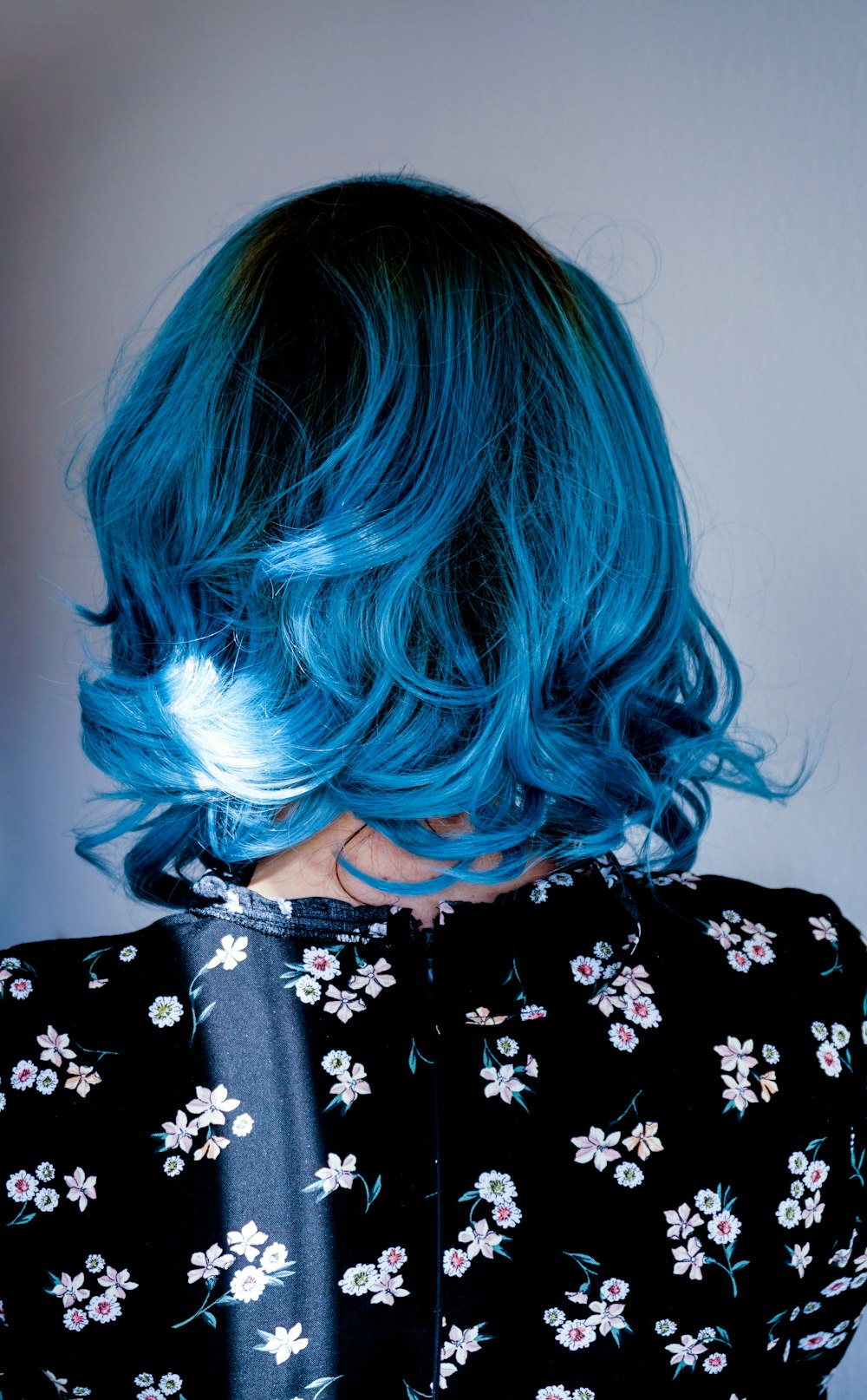 a woman with blue hair and a black dress