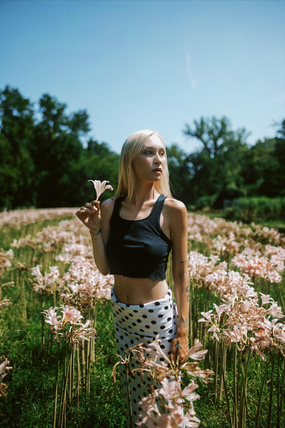 a woman standing in a field of flowers