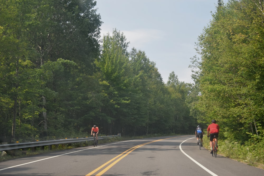 a group of people riding bikes down a road