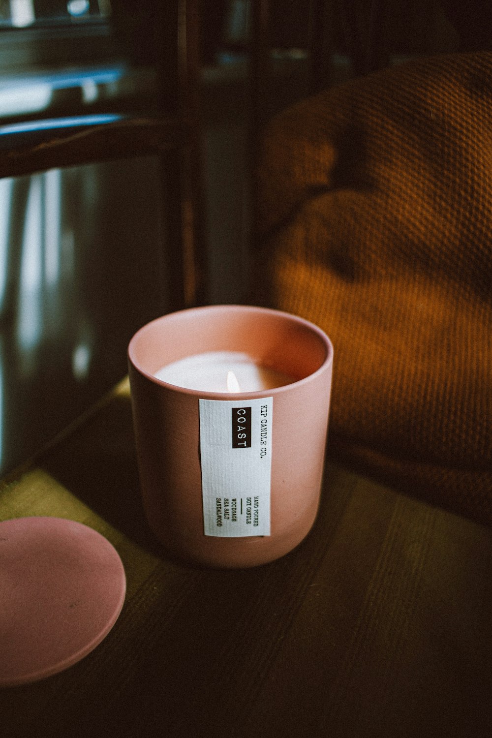 a pink cup sitting on top of a wooden table