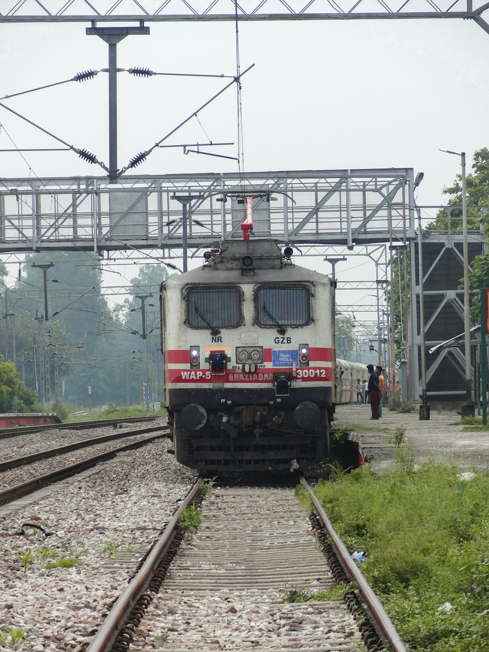 a train traveling down train tracks under a bridge