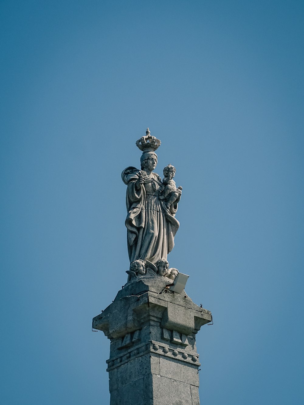 una statua di una donna con una corona in cima a un edificio