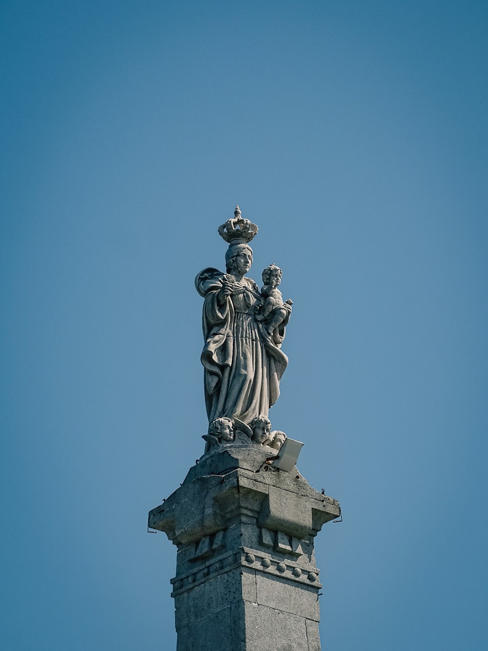 건물 꼭대기에 왕관을 쓴 여자의 동상