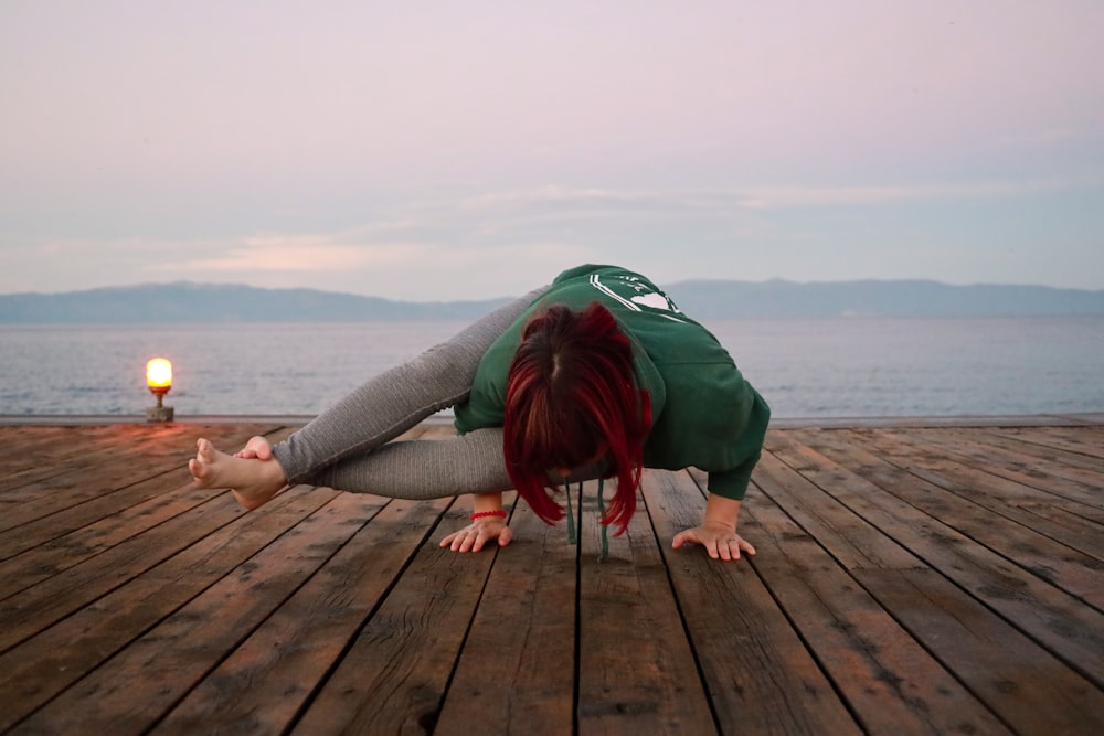 Eine Frau macht einen Handstand auf einem Dock