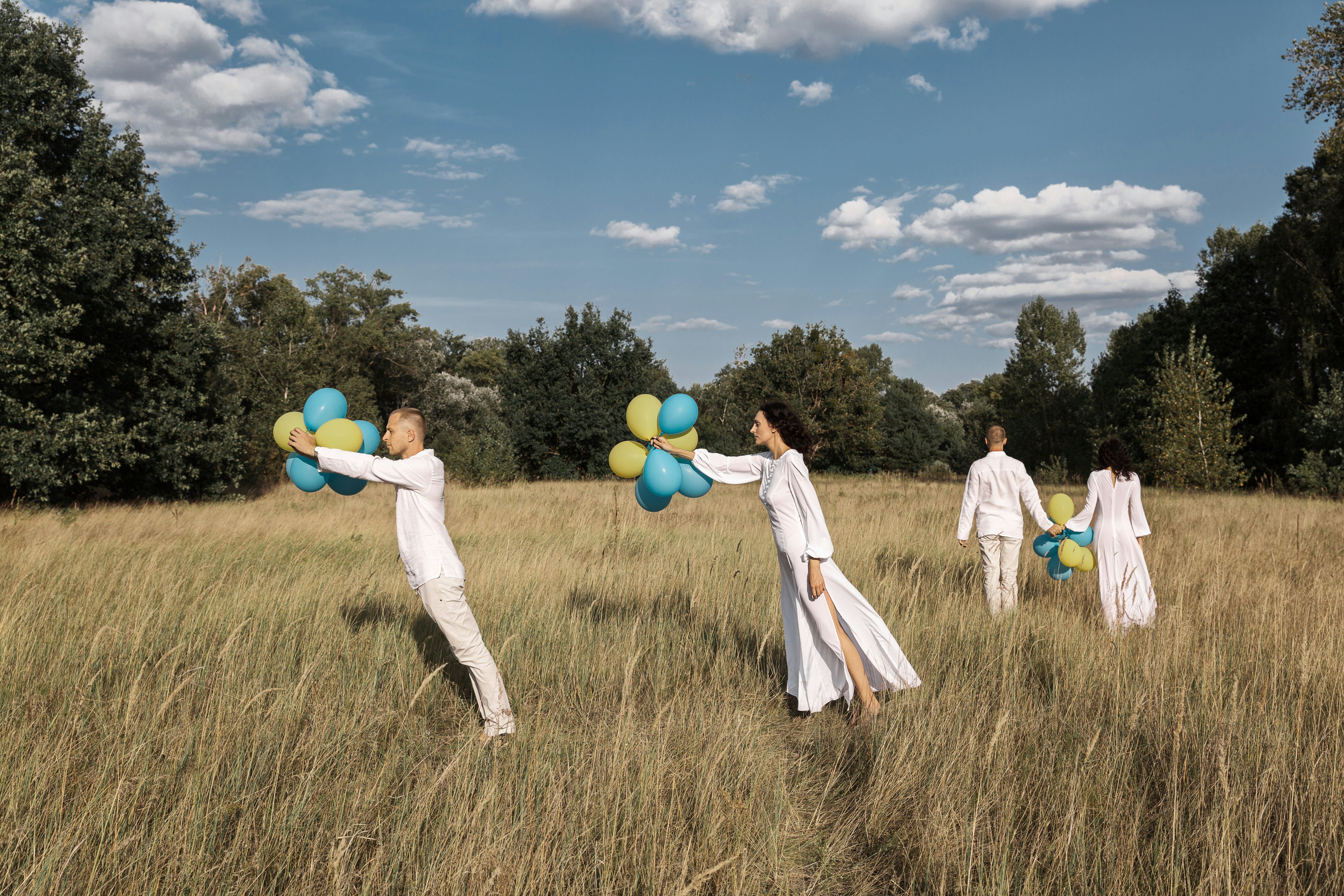a group of people in a field with balloons