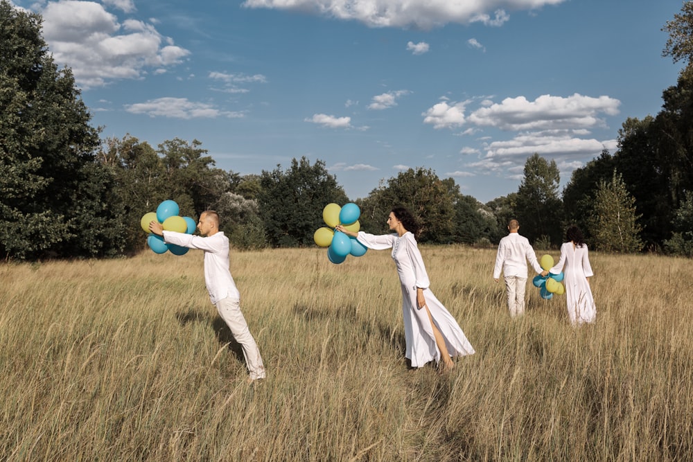 a group of people in a field with balloons