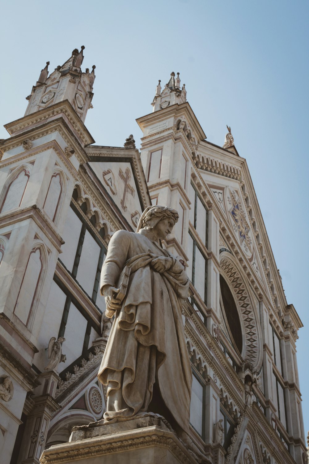 a statue of a man holding a book in front of a building