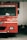 A red fire truck is parked indoors. The vehicle has various labels, including 'FIRE' and a license plate marked 'KA-01 G-8091'. Around the truck, other objects such as helmets and another vehicle can be seen.