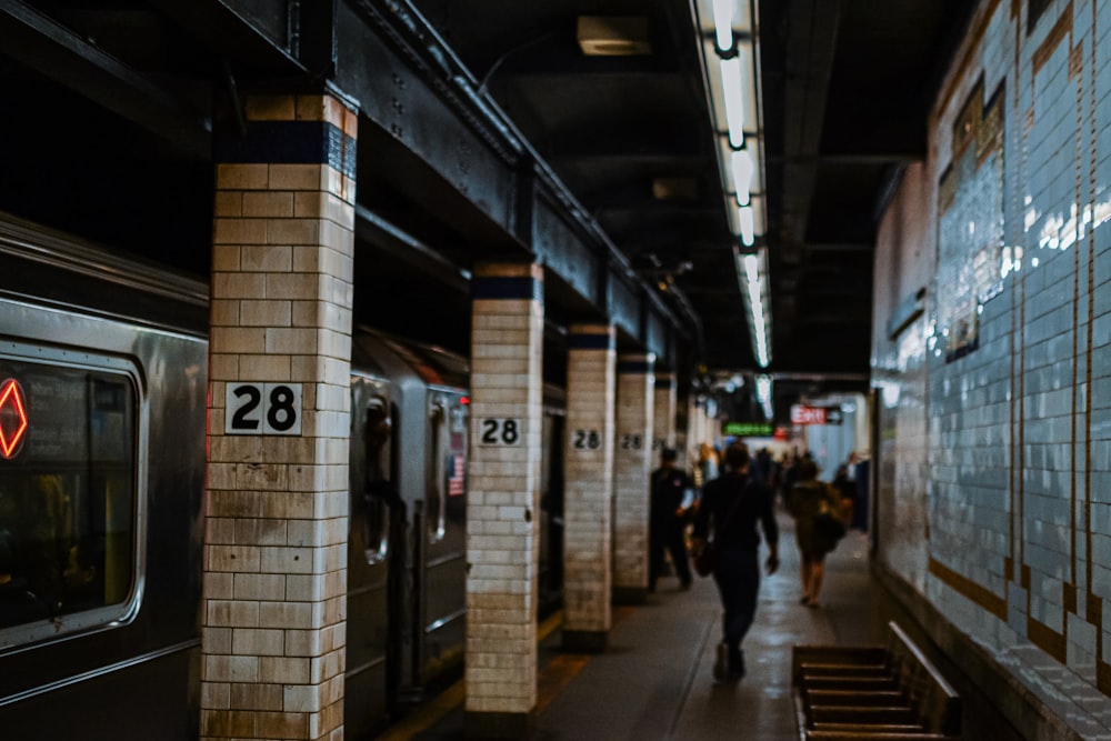 a subway station with people walking on the platform