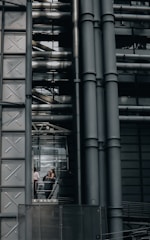 Engineers discussing plans in a bright industrial setting.