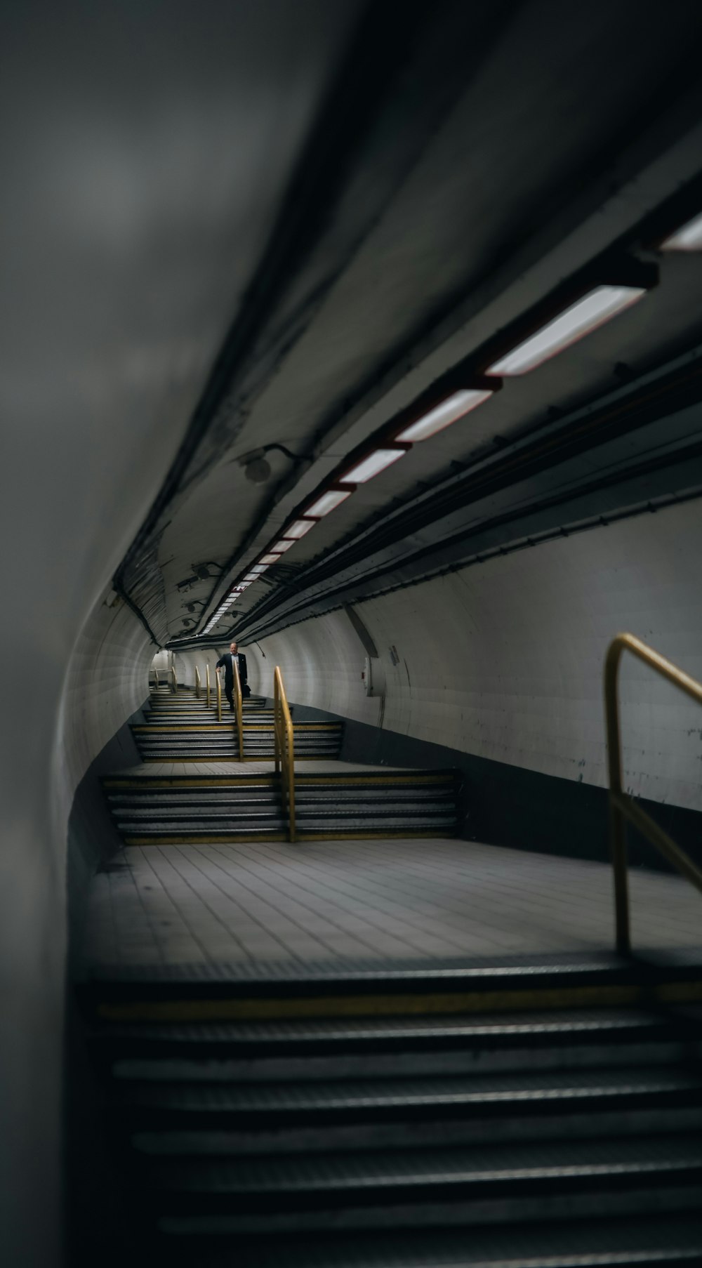 an empty subway station with stairs and railings