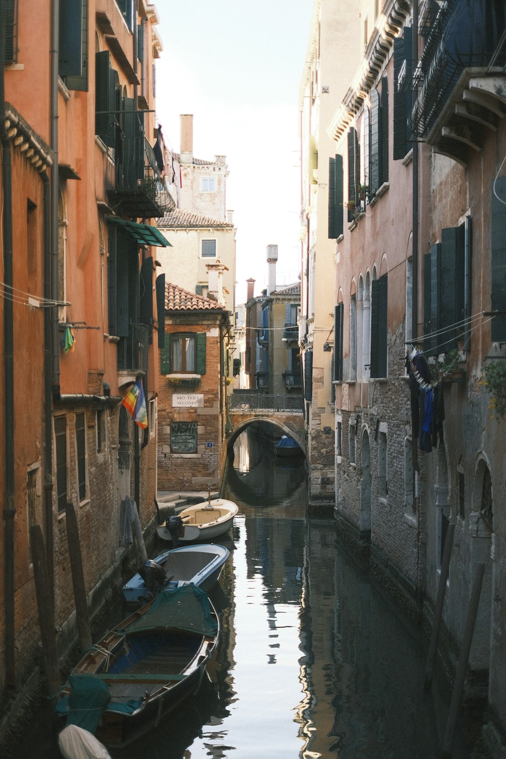 a narrow canal with several boats in it