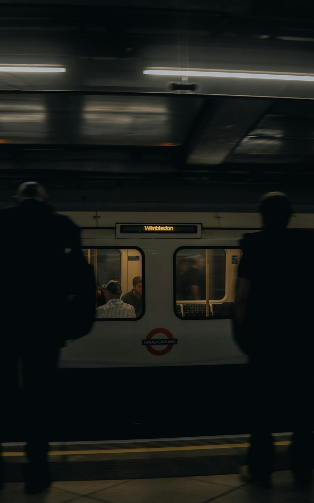 um grupo de pessoas ao lado de um trem do metrô