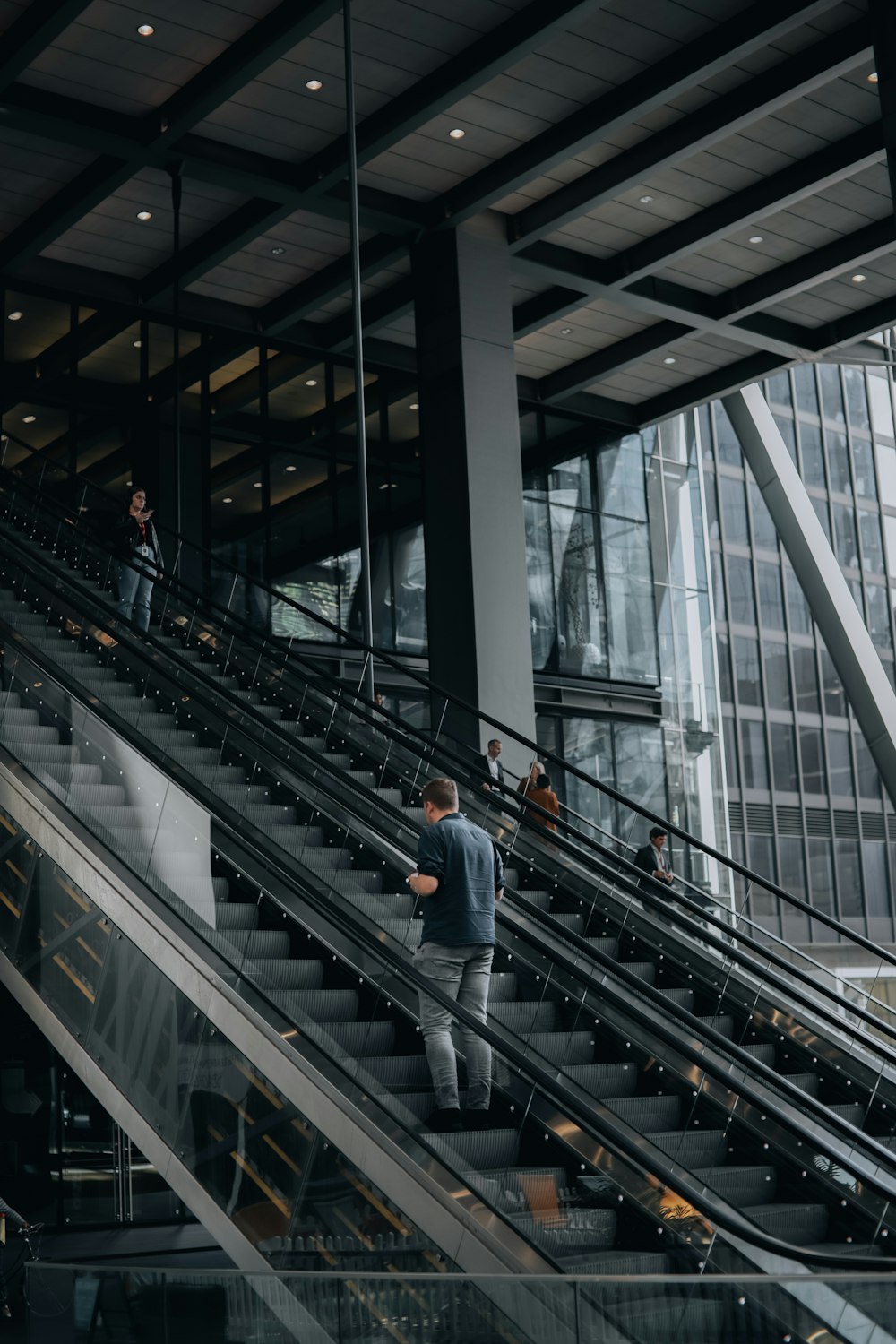 a man walking down an escalator in a building