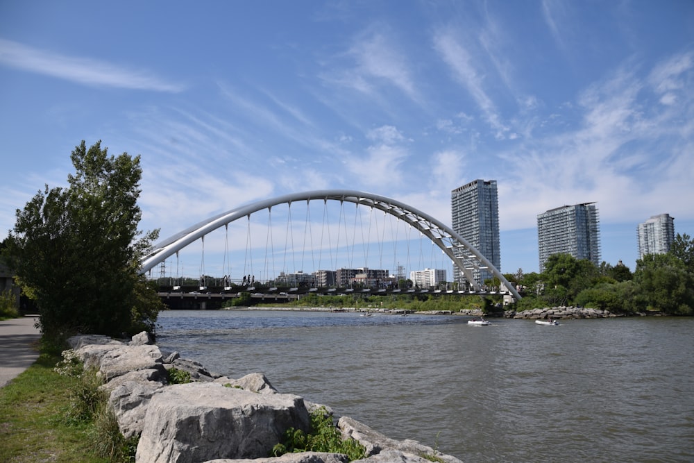 a bridge over a river with tall buildings in the background