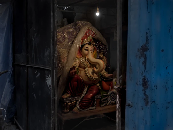A beautifully carved brass statue of Lord Ganesha glowing softly in warm light.